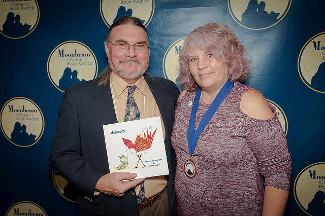 Johnna Langen with Awards Director Jim Barnes, holding her award-winning book Someday. 
